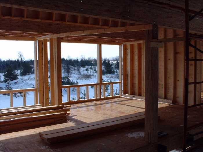 The second floor bedrooms looing south through the window frames. A third bedroom now has a wall to the far right.