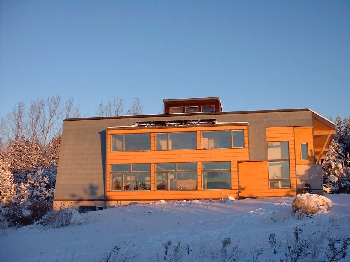 The photo voltaic solar panels which convert sunlight into electricity can be seen just above the windows on the second floor. The modules are a dark black colour. Ten individual modules have been int