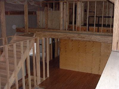 Kitchen is ready for installation. Stairs to the second floor have been put in place. The bridge is ready. The concrete pad for the wood stove has been prepared between the kitchen and dining room.