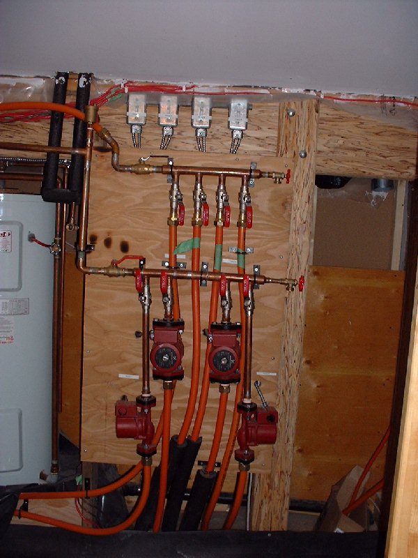 The flow of heated water into the tubing is provided by pumps for each zone. Each pump has a main shut off switch at the top of the picture. To the left side, with the black foam pipe insulation, is t