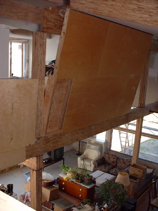 The wall in the spare bedroom meets the ceiling at a right angle providing wall that leans into the dining room. The living room downstairs has been temporarily set up for guests but for now is mainly