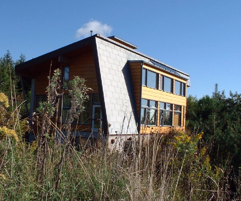 Leigh walks back to the house. The wind turbine is visible to the left.