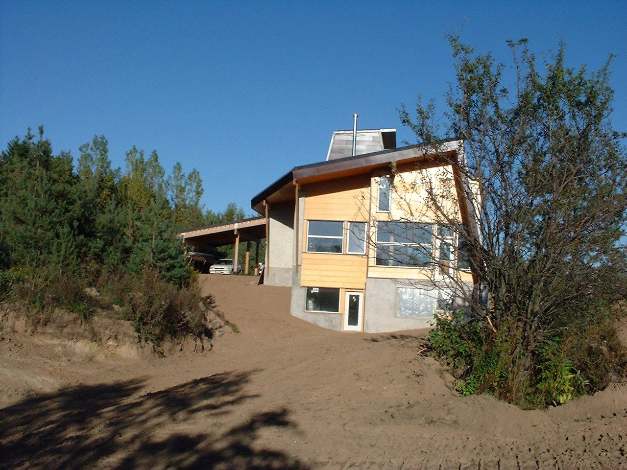 Extensive grading last Friday has opened up some space around the house. The natural flow of water away from the house is seen here on the west side. The walk out from the basement provides lots of li