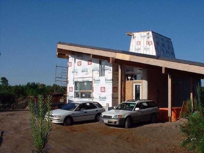 The main doors have been installed. A morning sun warms up the east side of the house.