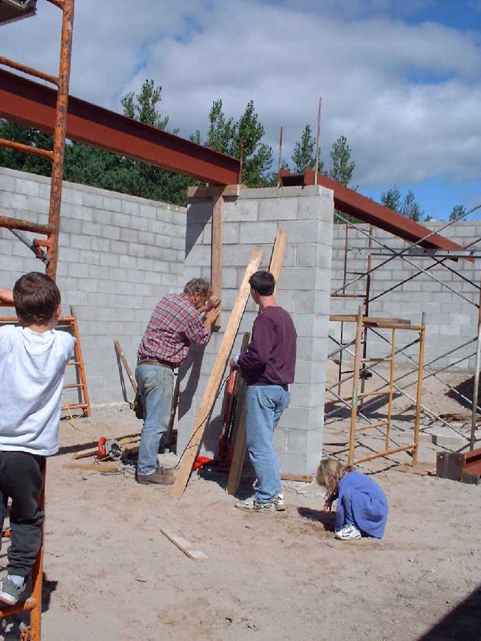 The steel beams hold up the heavy concrete floor as well as the vegetative roof that will eventually rest on these posts. Colin gets expert help from the Wilson family as the critical height for the g