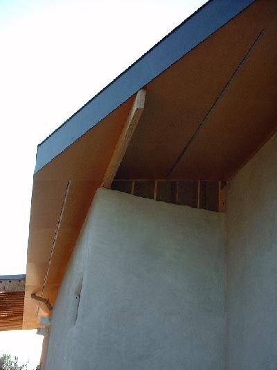 The straw bale walls are finished with extra insulation. Birch ply wood is used for the soffit. Dark lines the roof and the blond is used underneath.