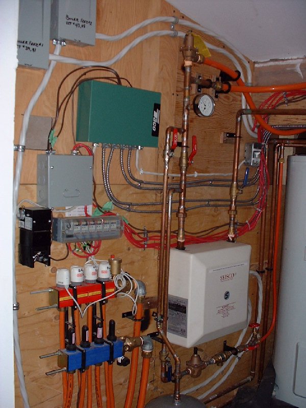 The square white unit with the Seisco label is the main "furnace" for the entire house. This ultra-efficient water heating device uses electricity to heat water on demand to be supplied to zones in th