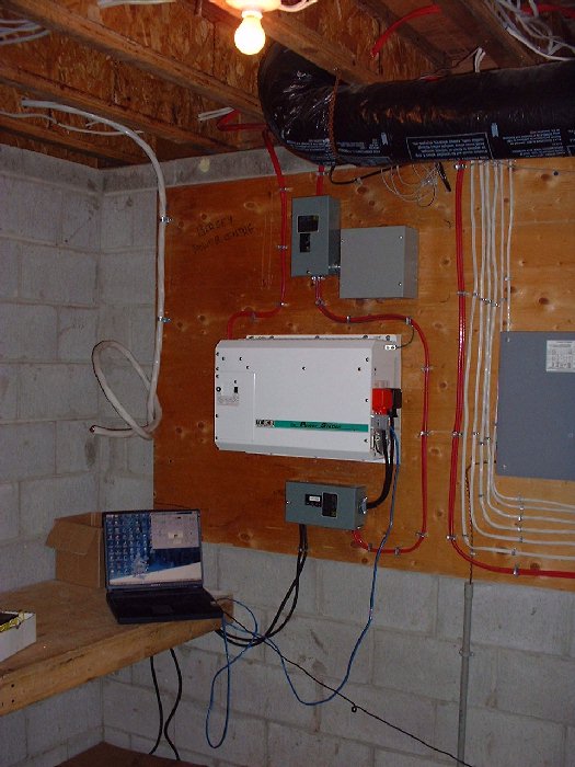The photo voltaic solar panels and the future wind turbine cables terminate in our electrical room. They are connected into the inverter (the white box on the wall in the middle of the picture). The w