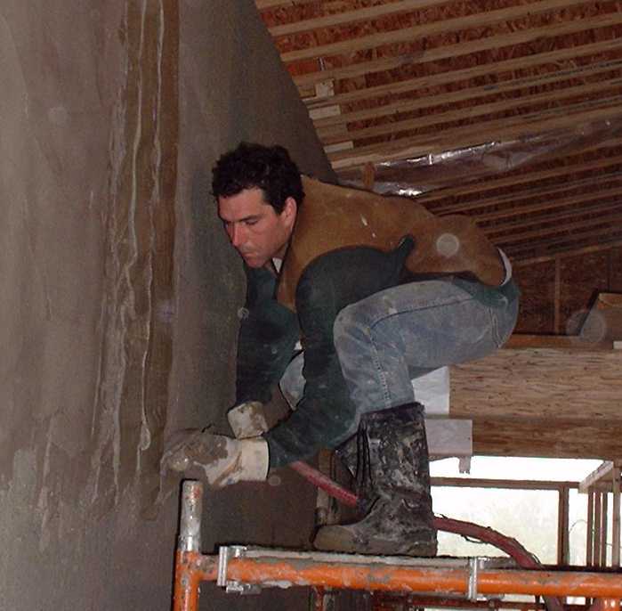 Bill demonstrates a new invention, created by Peter Mack, a trowel that supplies a continuous stream of plaster pumped through a large hose attached. This new device worked very well at keeping the me