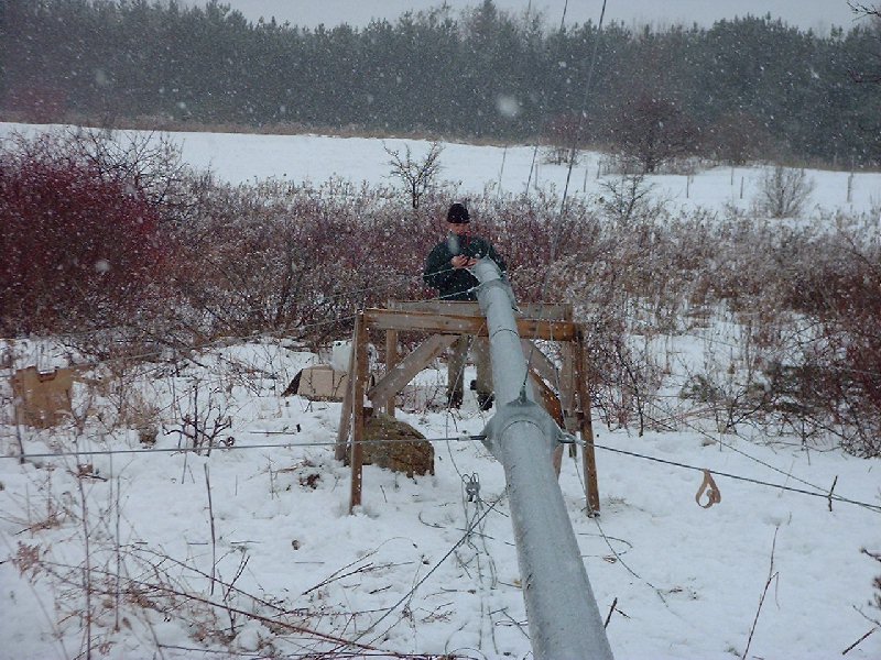 Ben prepares the base of the tower for the wind turbine. The tower is 60 feet high. The electrical wiring is being installed before raising the tower.