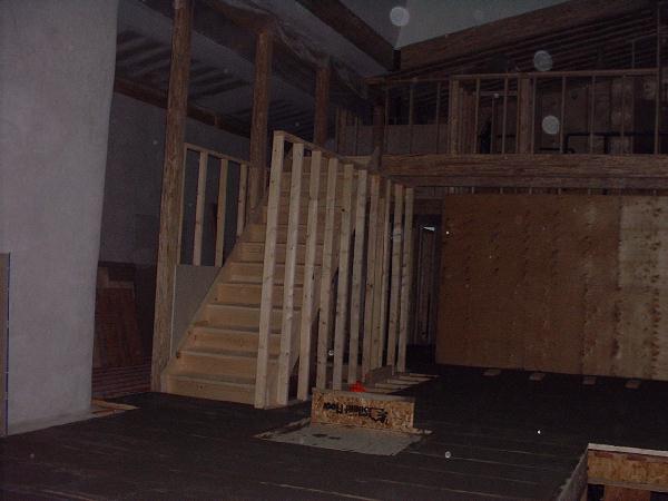 The stairs to the second floor arrived and the framing for the kitchen cabinets has been prepared. The bridge over the kitchen can be seen although the railing has not yet been built.