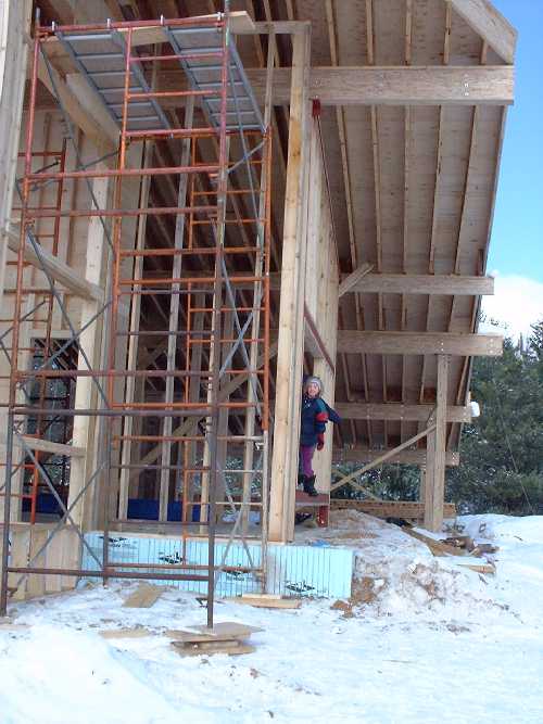 Claire peeks through the future master bedroom window on the east side. To the left is a new doorway to the green house.