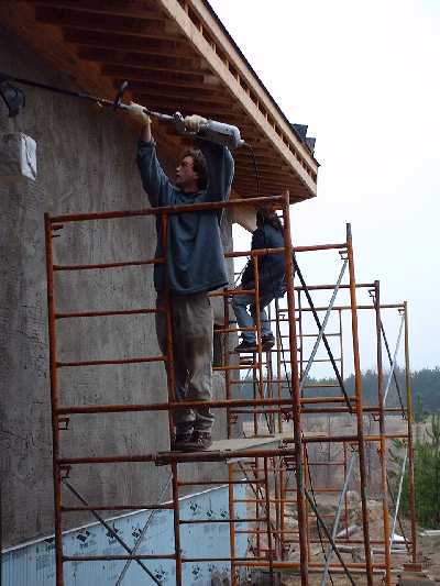 Brothers, Thomas and James, use a weed wacker to trim off the last few bits of straw.