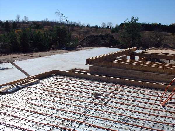 The master bedroom looking south west into the living room (left) and kitchen (right). Here the concrete has been poured in the living room to the south while the master bedroom in the foreground awai