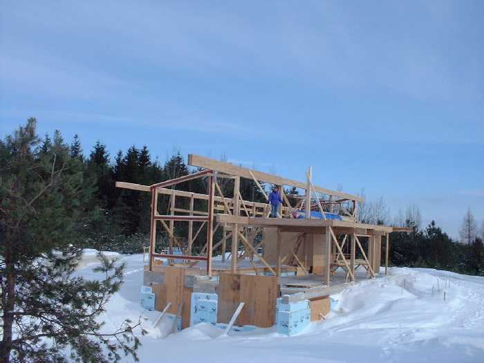 Leigh stands in the spare bedroom on the far west side of the second floor. The first post on the south side of the second floor shows where the last row of posts will go.
