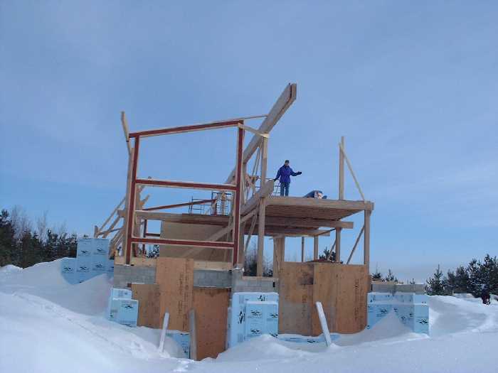 Leigh stands in the spare bedroom on the far west side of the second floor. The first post on the south side of the second floor shows where the last row of posts will go.