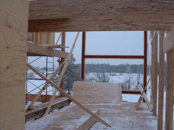 The kitchen gets a large window view through the west steel frame. The bridge on the second floor is open above the kitchen.