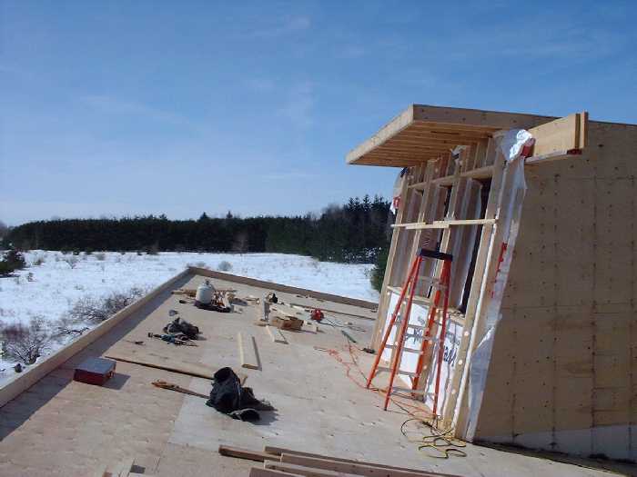 Looking west on the roof. The three large windows will provide light and ventilation through the center of the house. On each side of the sky light solar hot water heaters will help store heated water