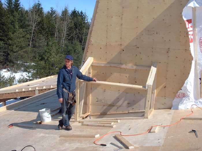 Doug stands next to the wood burning stove chimney frame. EPA rated high efficiency, a sealed wood burning stove will be used for extra heating during long periods of cold and dull days. Wood from the